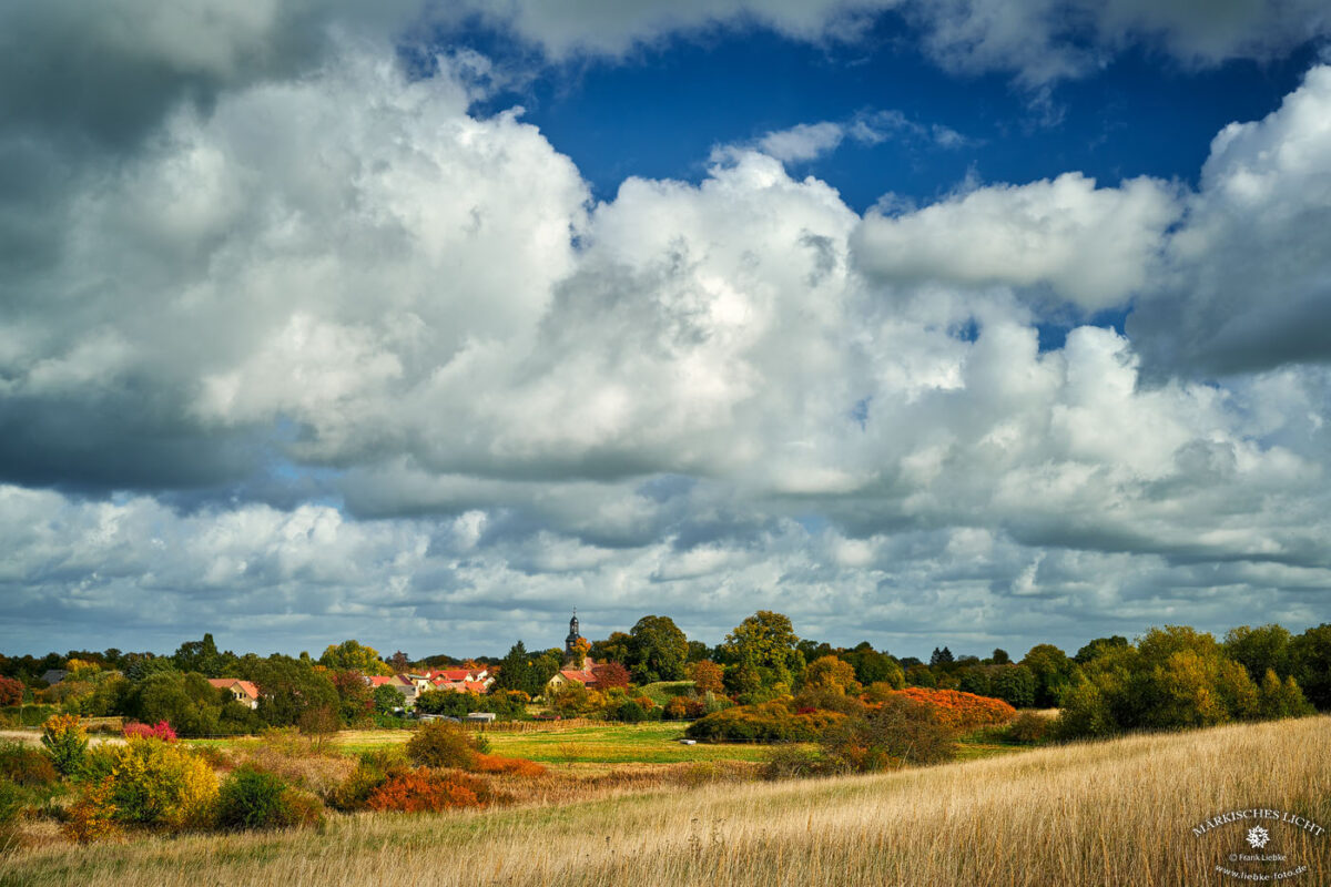 Blick nach Vehlefanz. Gut im Licht: die Kirche, umgeben von Herbstfarben.