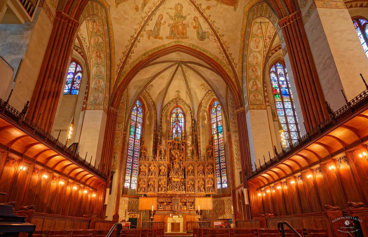 Blick zum reichlich verzierten, geschnitzten Altar. Schleswig, Dom